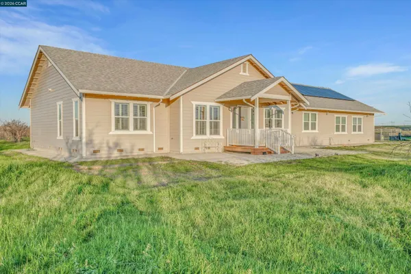a front view of a house with a yard and trees