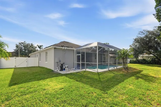 a view of a house with backyard and a tree