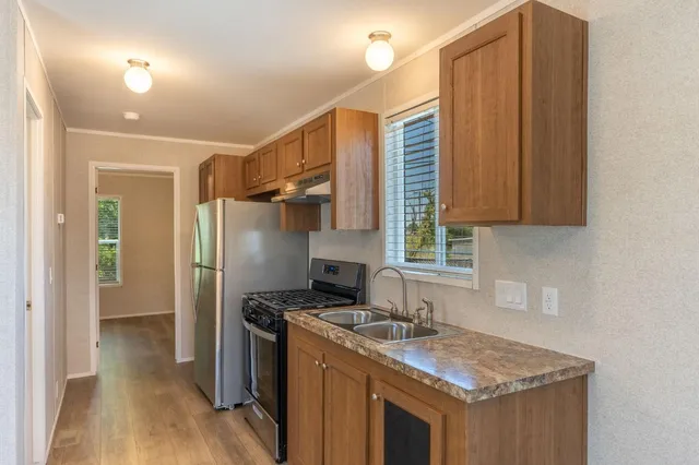 a kitchen with granite countertop a sink stove and refrigerator