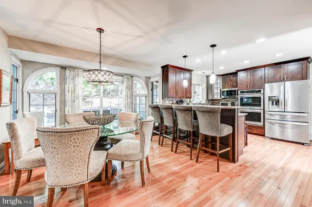 a view of a dining room and livingroom with furniture wooden floor a chandelier