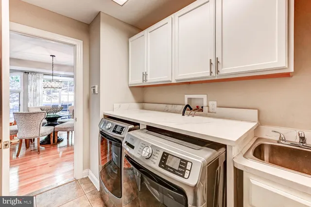 a utility room with dryer washer and a view of living room