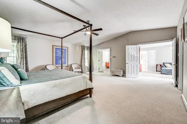 a spacious bedroom with a large bed and a chandelier