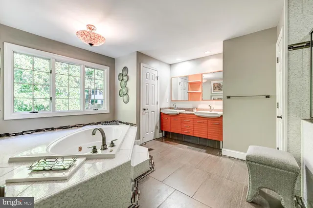 a bathroom with a tub sink and mirror