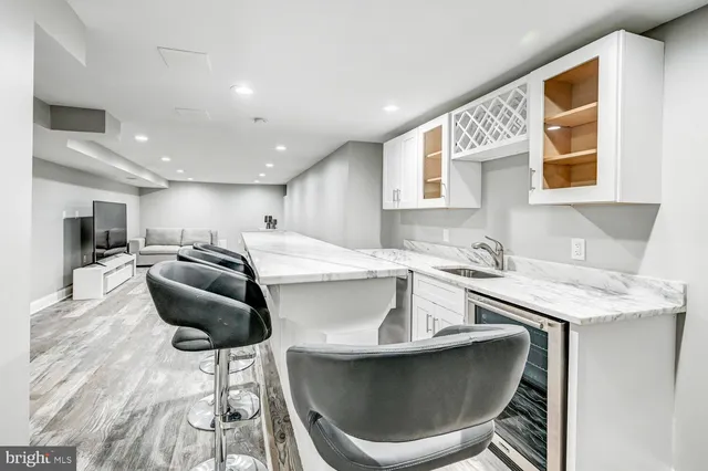 a kitchen with stainless steel appliances kitchen island granite countertop a sink and a white cabinets