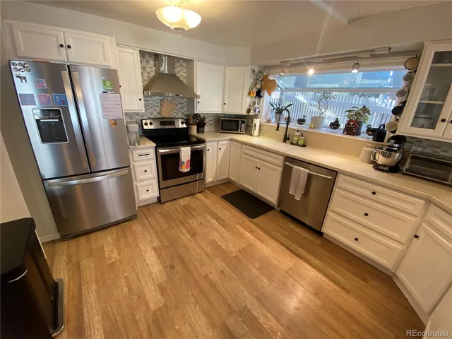 a kitchen with granite countertop a refrigerator stove and sink
