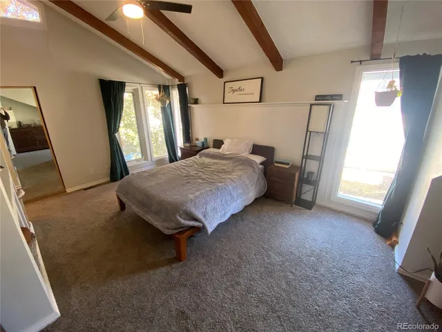 a spacious bedroom with a bed and a large window