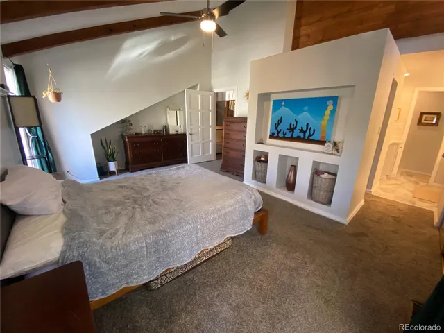 a spacious bedroom with a bed and a flat screen tv