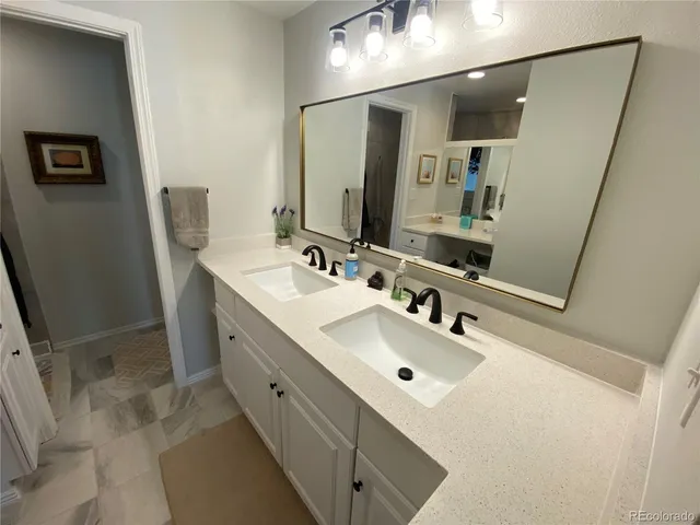 a bathroom with double vanity sink and mirror