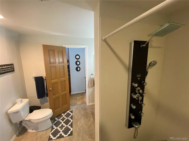 a bathroom with a toilet and a shower
