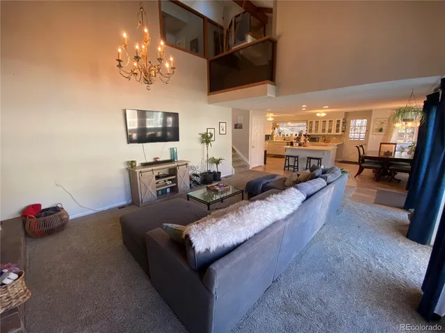 a living room with furniture and a chandelier