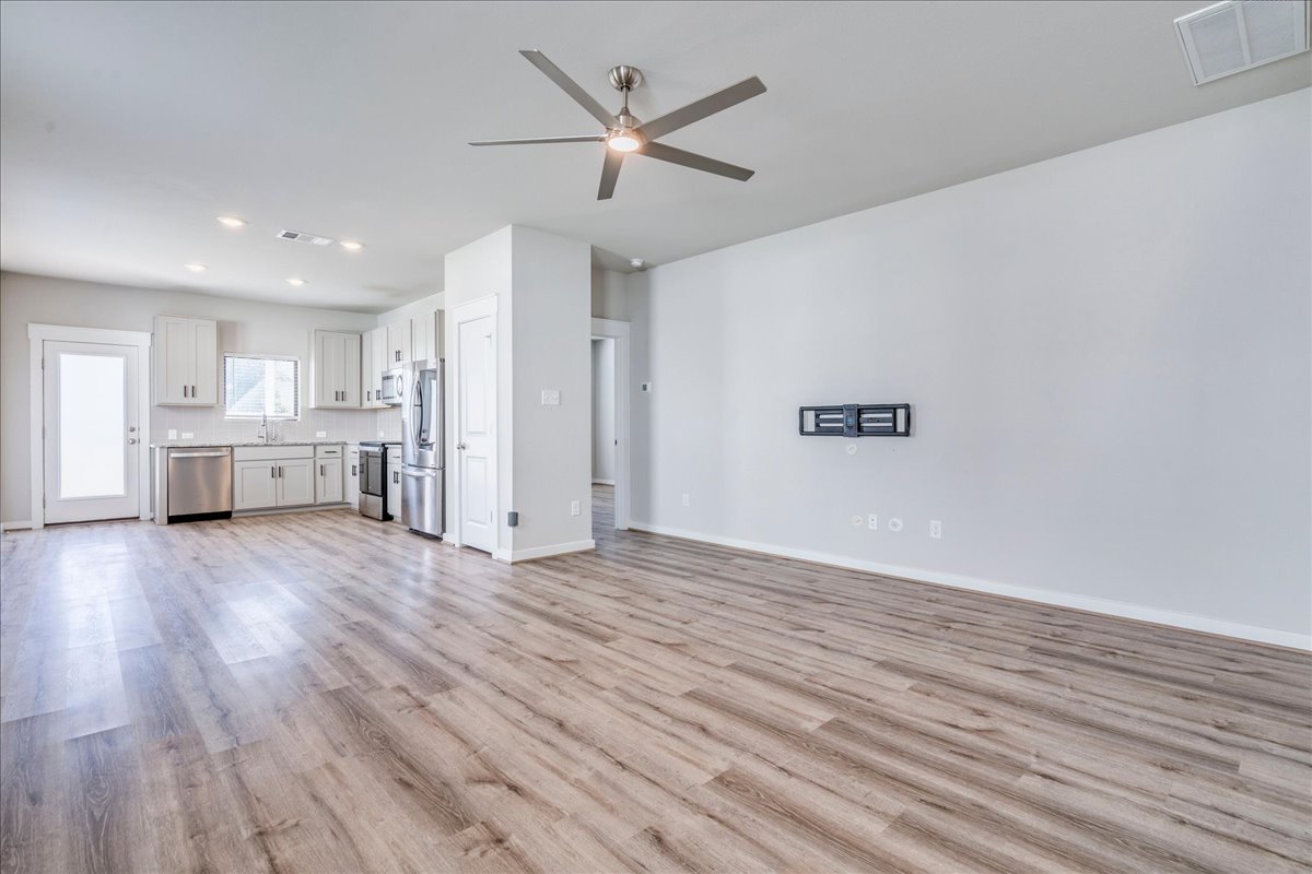 144 Threshing Road, Unit A Buda, TX 78610 - Photo 6 of 35 Living room with ceiling fan and tv mount. LVP flooring throughout the lower level.