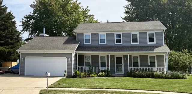 a front view of a house with a garden and plants