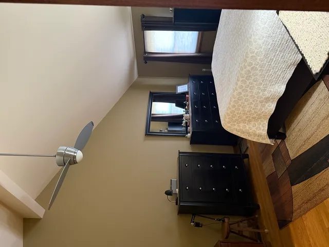 a bedroom with a bed and a lamp on dresser