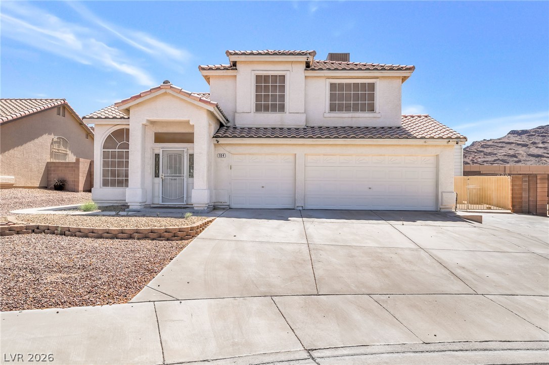 104 Appian Way Henderson, NV 89002 - Photo 2 of 24 A well-maintained facade features a prominent two-car garage and a tiled roof.