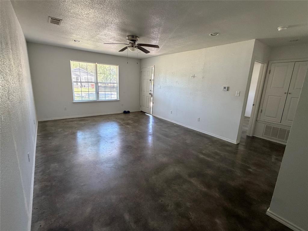 712 Seven Oaks Road, Unit 712 Bonham, TX 75418 - Photo 3 of 14 an empty room with wooden floor and windows