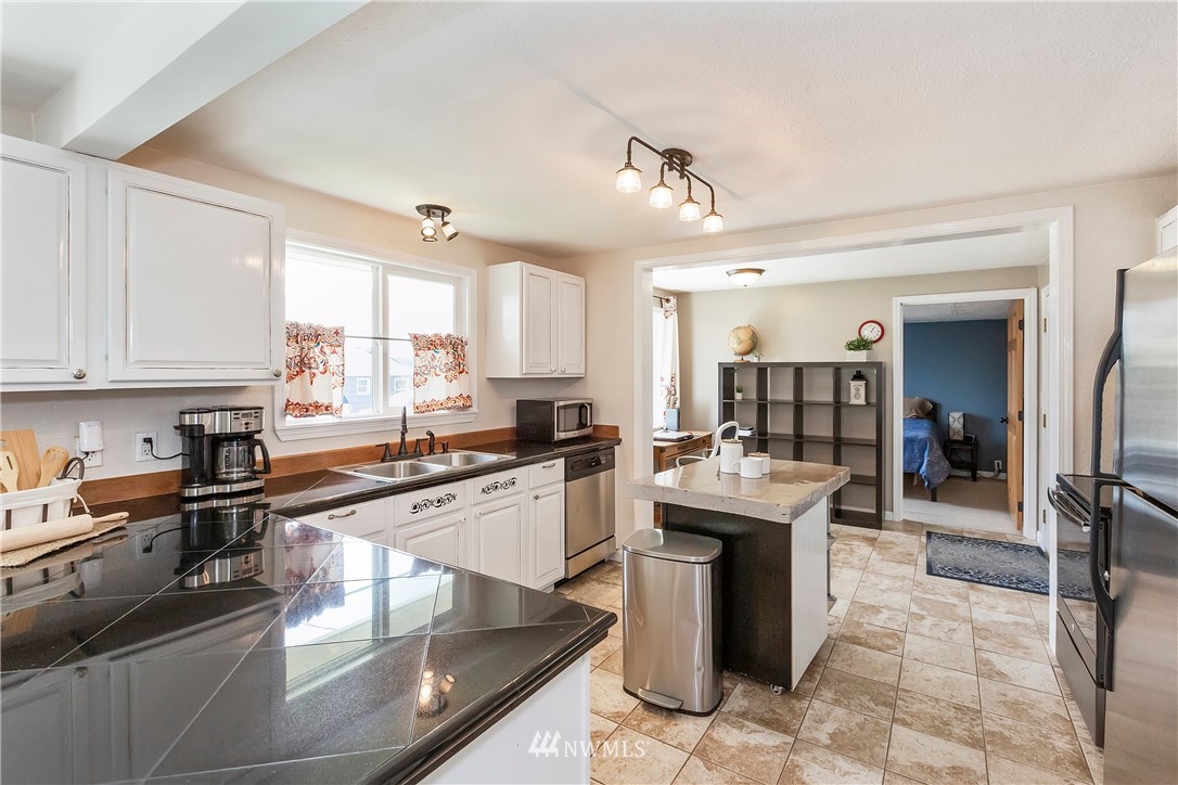 3604 Madrona Street Bremerton, WA 98312 - Photo 9 of 37 a kitchen with stainless steel appliances granite countertop a sink stove and refrigerator