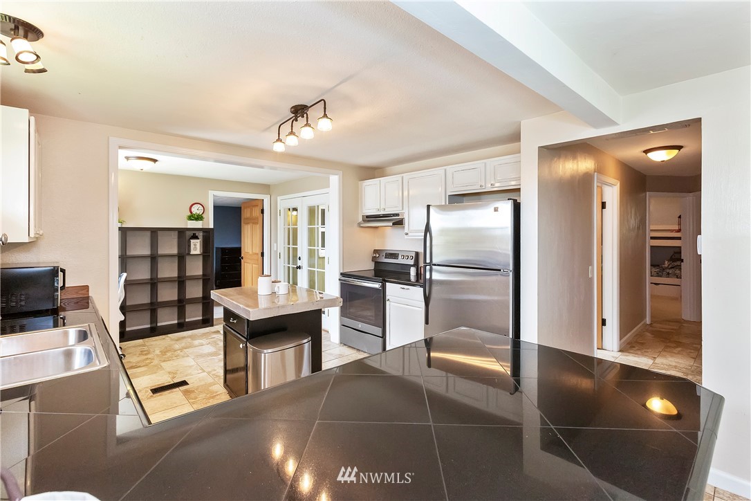 3604 Madrona Street Bremerton, WA 98312 - Photo 10 of 37 a kitchen with stainless steel appliances granite countertop a refrigerator and a stove top oven