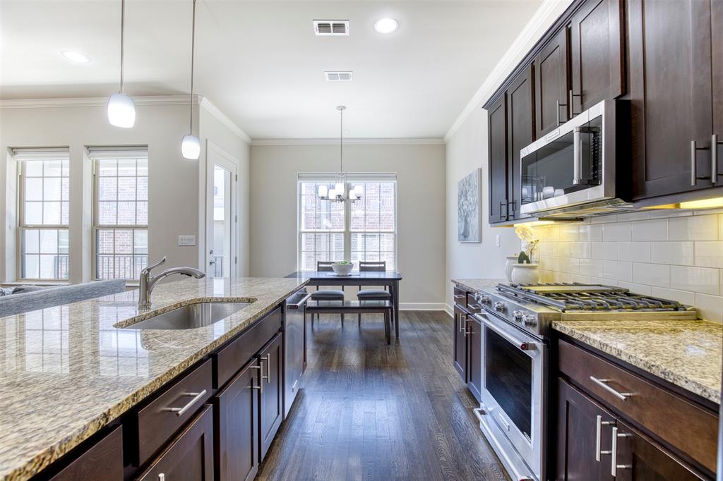 5005 Meridian Lane, Unit 3102 Addison, TX 75001 - Photo 13 of 34 a kitchen with granite countertop a stove a sink and wooden cabinets