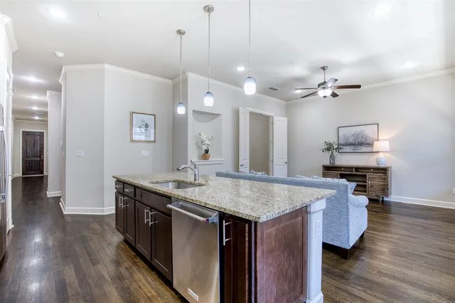 a kitchen with kitchen island a sink dishwasher a stove and a refrigerator with wooden floor