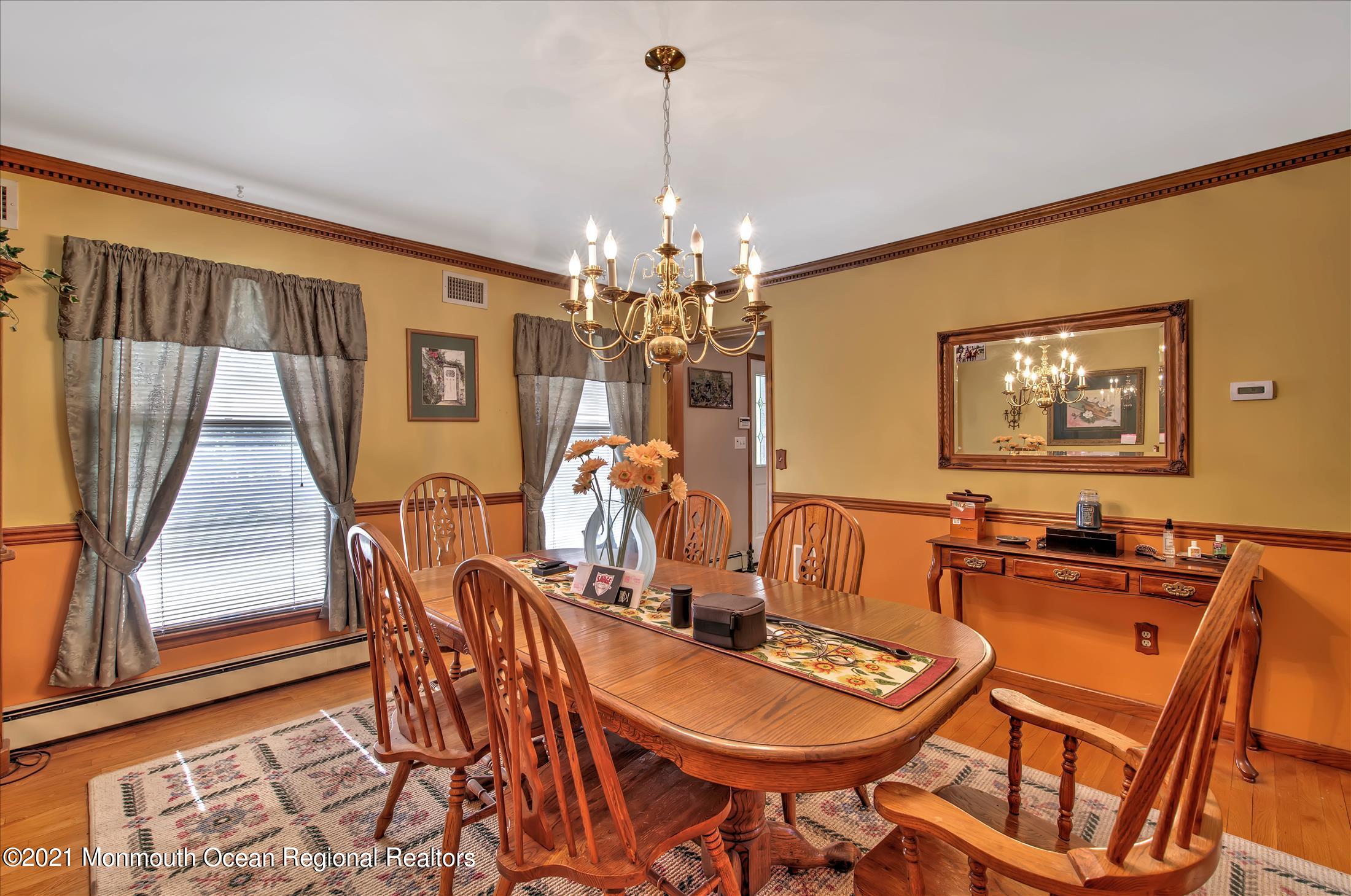 58 Brookside Road Millstone Township, NJ 08510 - Photo 11 of 34 a dining room with furniture a chandelier and wooden floor