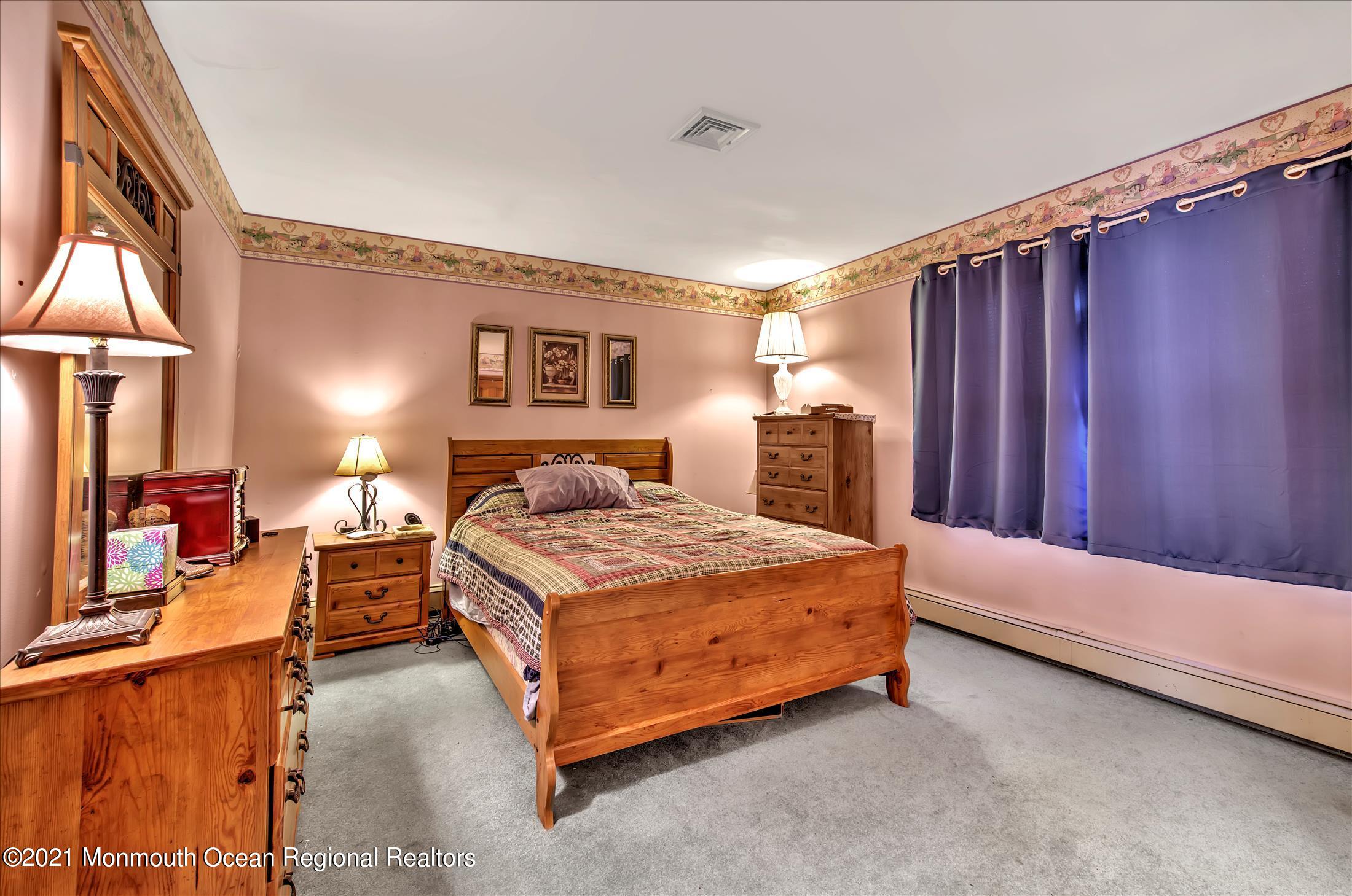58 Brookside Road Millstone Township, NJ 08510 - Photo 26 of 34 a bedroom with a bed and lamp with the dresser