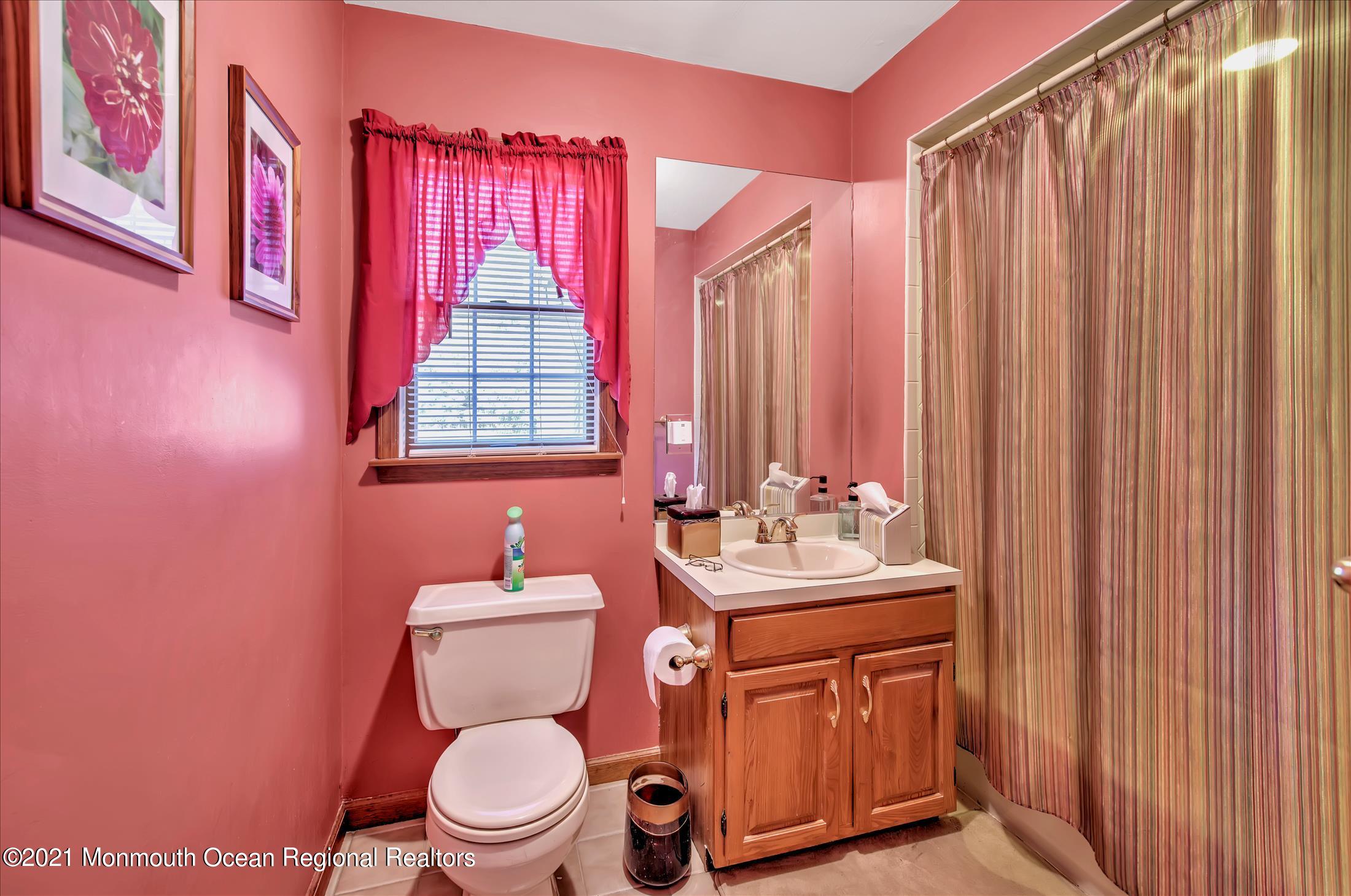 58 Brookside Road Millstone Township, NJ 08510 - Photo 27 of 34 a bathroom with a sink a toilet and shower curtain