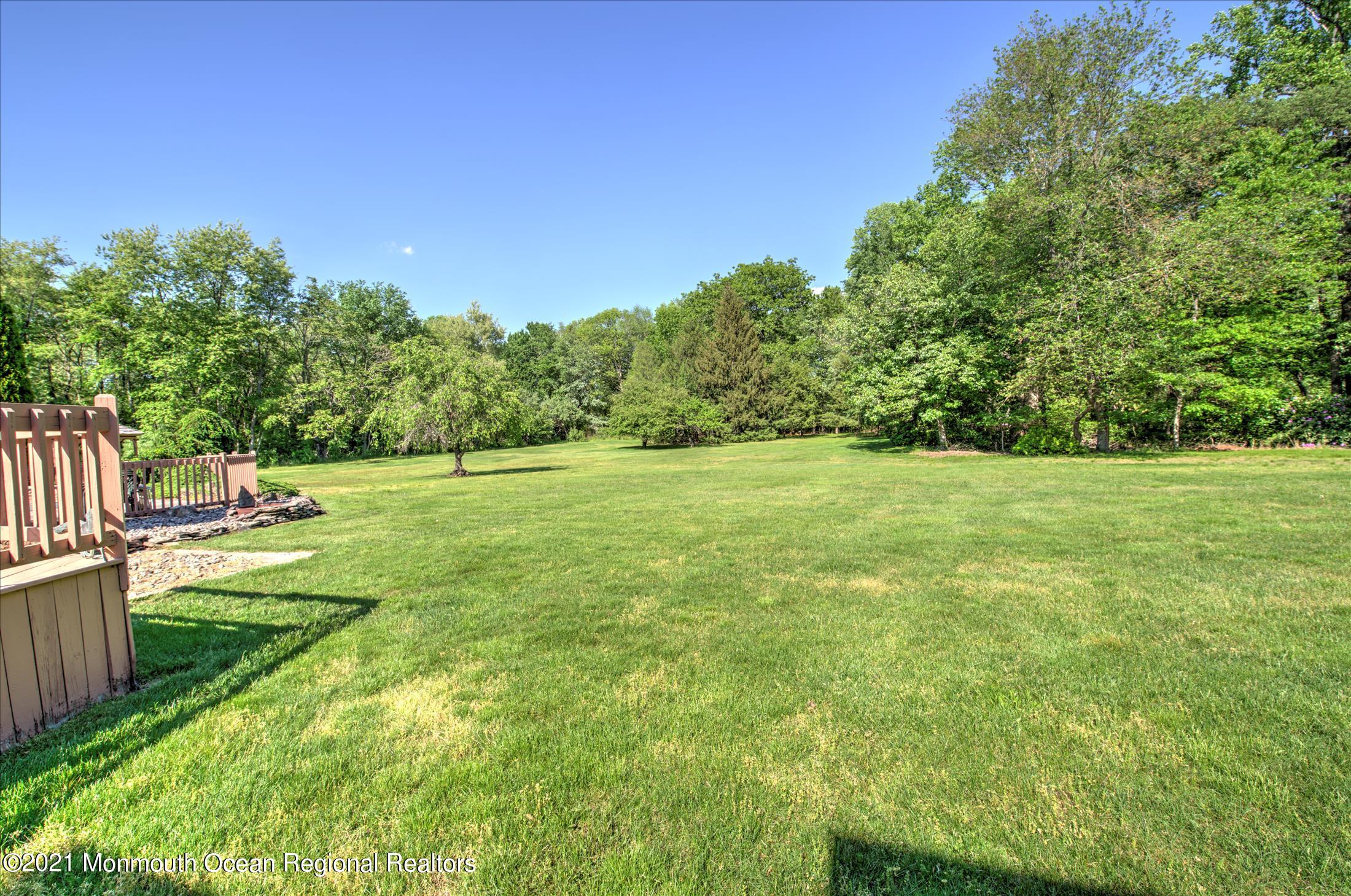 58 Brookside Road Millstone Township, NJ 08510 - Photo 30 of 34 a view of a grassy field with trees in the background