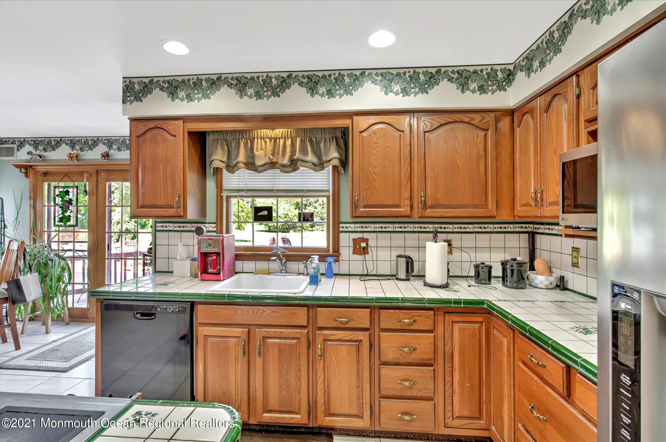 58 Brookside Road Millstone Township, NJ 08510 - Photo 9 of 34 a kitchen with stainless steel appliances a sink dishwasher and cabinets with wooden floor