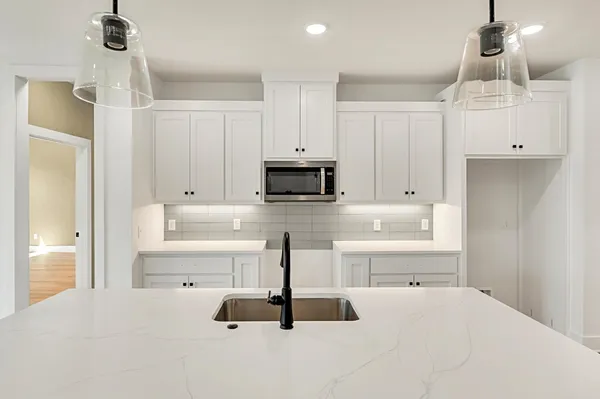 a kitchen with kitchen island a counter top space appliances and cabinets