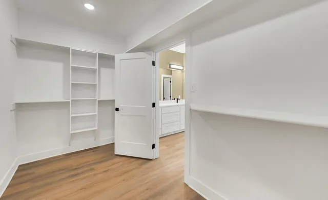 a view of an empty room with cabinet and wooden floor