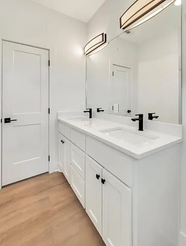 a bathroom with a double vanity sink and mirror