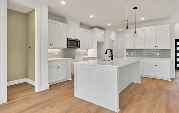a kitchen with kitchen island a sink stainless steel appliances and cabinets