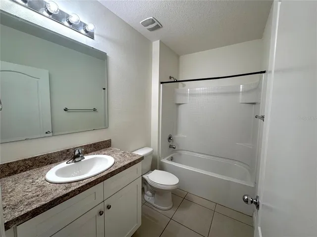 a bathroom with a granite countertop sink toilet a mirror and shower