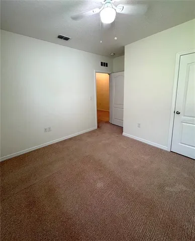 an empty room with a bathroom and a mirror