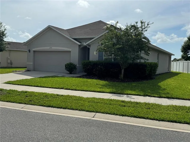 a front view of a house with a garden and yard