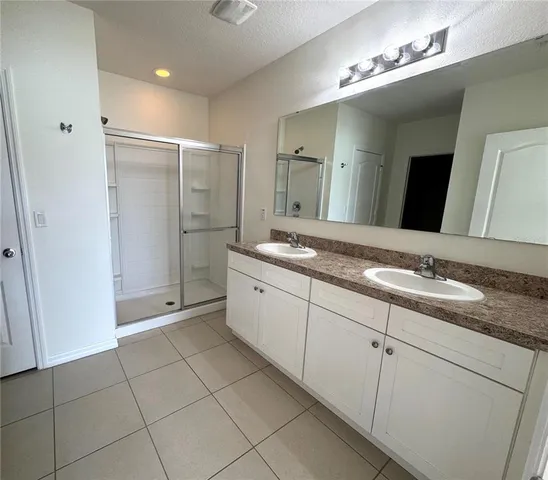 a spacious bathroom with a double vanity sink and a mirror