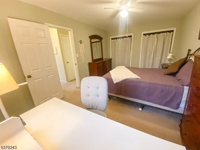 a bedroom with a bed and a mirror on the dresser