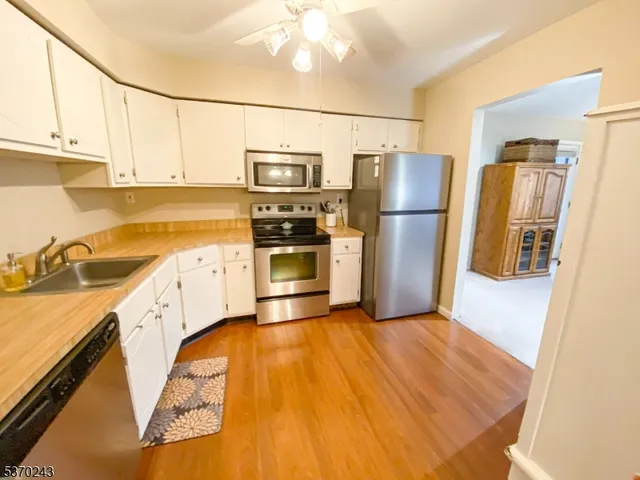 a kitchen with stainless steel appliances granite countertop a refrigerator a stove and a sink with cabinets