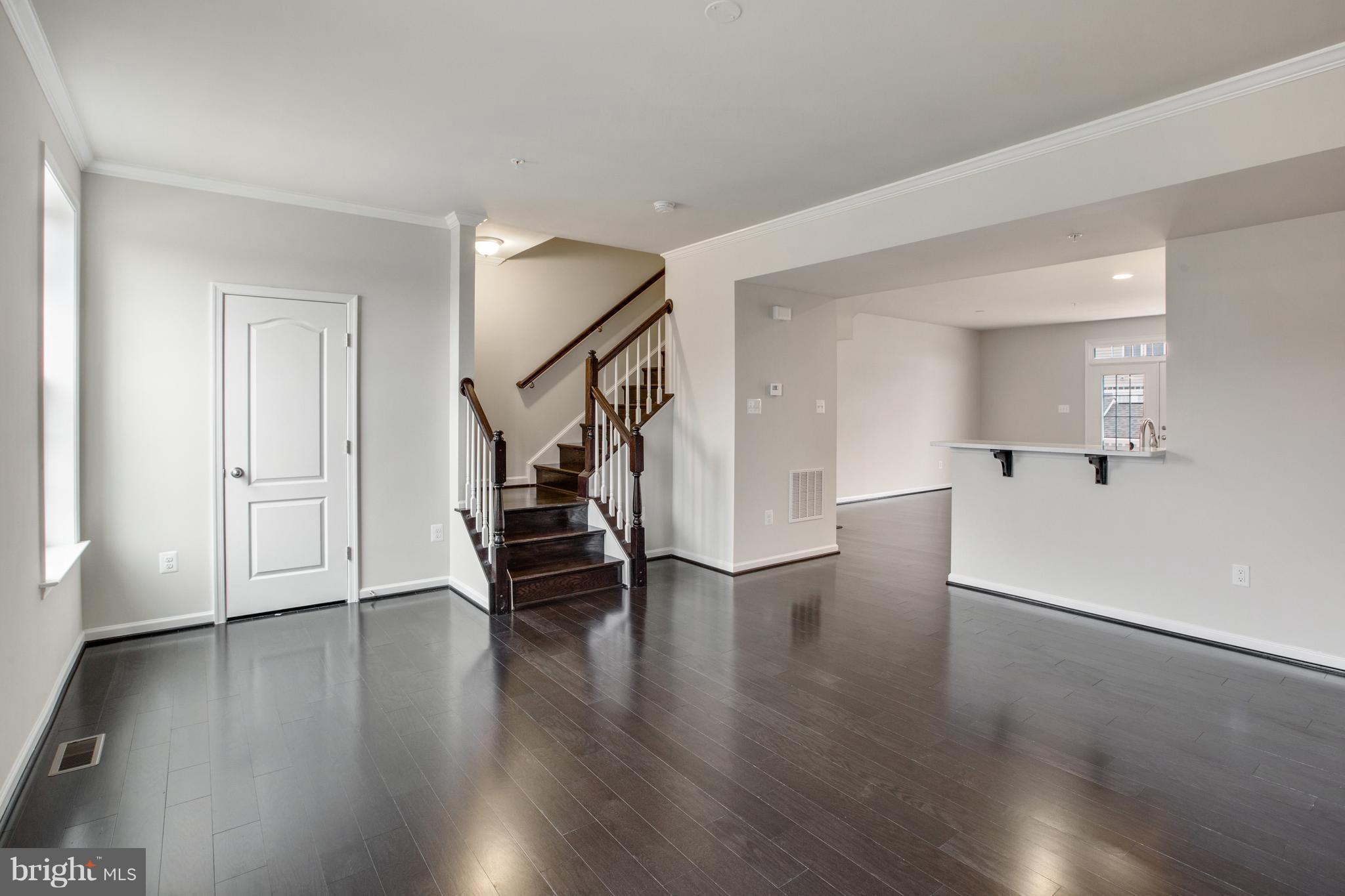 7871 Wormans Mill Road Frederick, MD 21701 - Photo 13 of 30 a view of empty room with wooden floor and stairs
