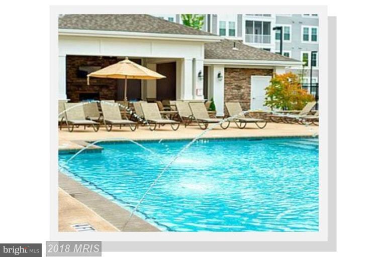 7871 Wormans Mill Road Frederick, MD 21701 - Photo 28 of 30 a view of a swimming pool with a table and chairs under an umbrella