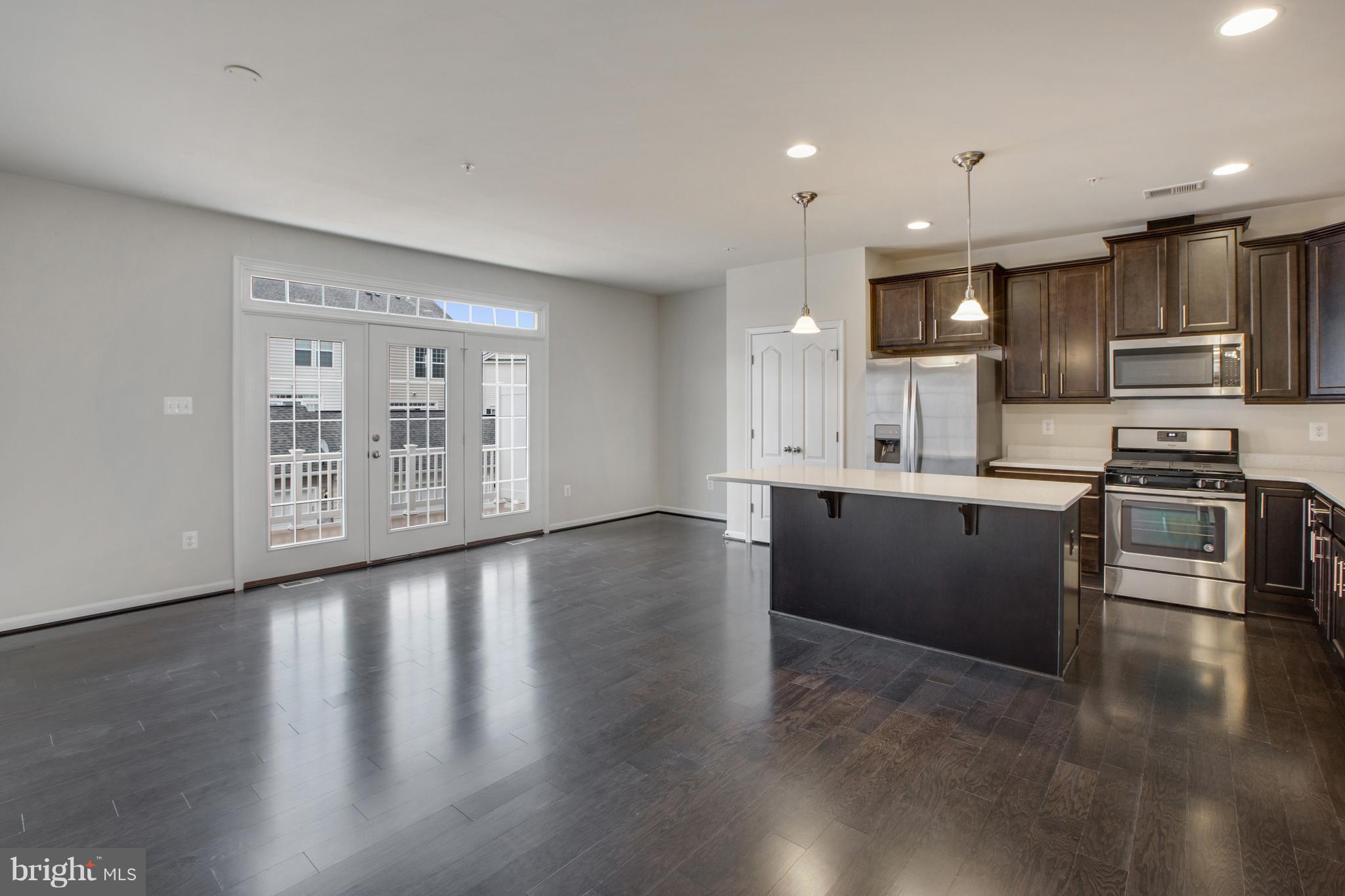 7871 Wormans Mill Road Frederick, MD 21701 - Photo 6 of 30 a kitchen with stainless steel appliances kitchen island granite countertop a stove a sink and a refrigerator