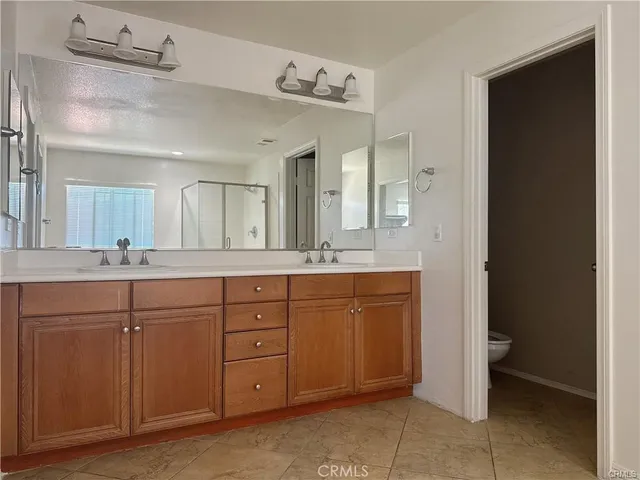 a spacious bathroom with a granite countertop sink and a mirror