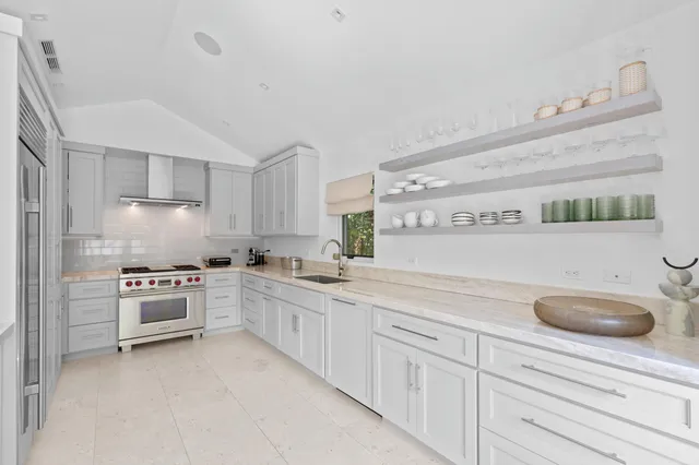 a kitchen with granite countertop white cabinets and white stainless steel appliances