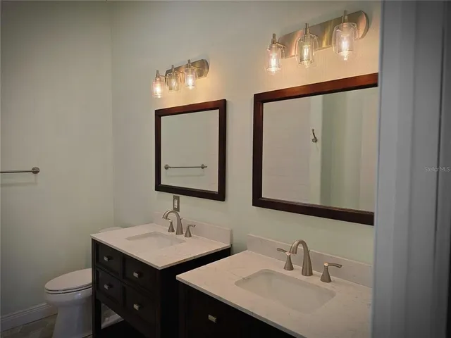 a bathroom with 2 sink and a mirror