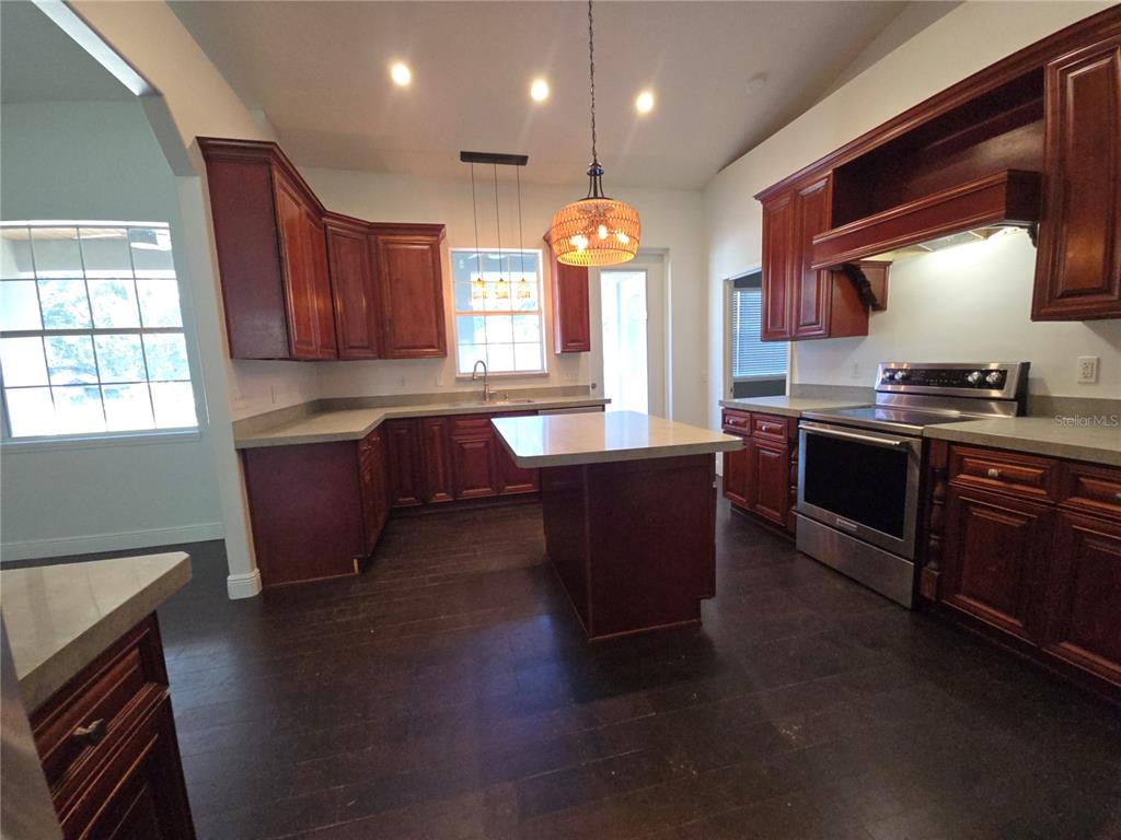 27410 Yalaha Cut Off Road Yalaha, FL 34797 - Photo 2 of 22 a kitchen with stainless steel appliances granite countertop a sink stove and wooden cabinets
