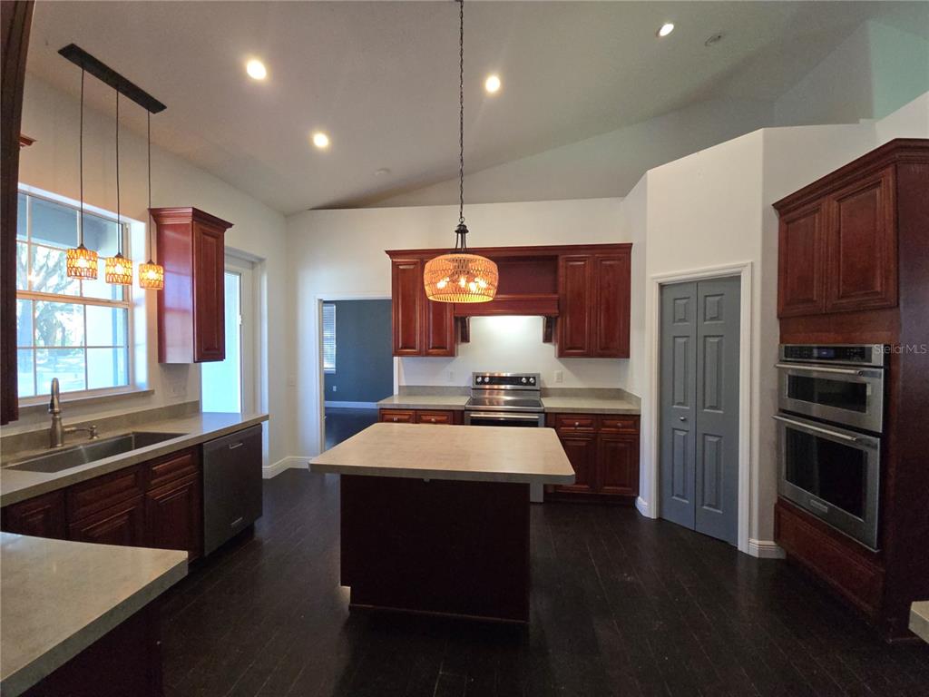 27410 Yalaha Cut Off Road Yalaha, FL 34797 - Photo 10 of 22 a kitchen with stainless steel appliances a sink stove and refrigerator