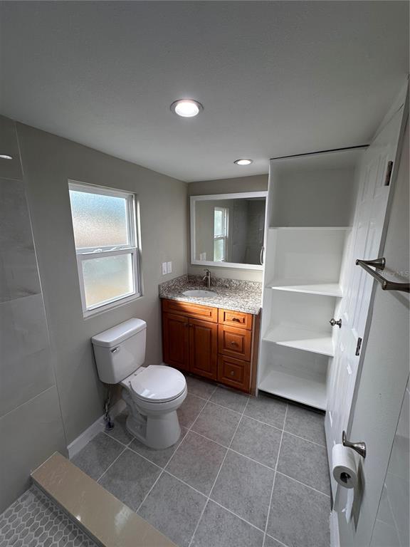 16083 Naples Street Brooksville, FL 34604 - Photo 16 of 16 a bathroom with a granite countertop toilet a sink and a bathtub
