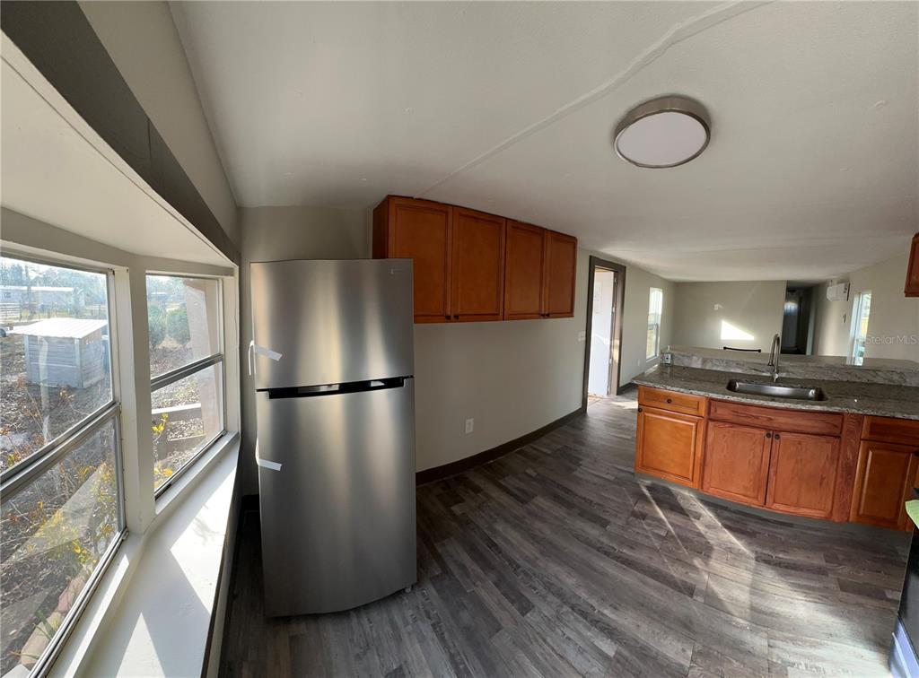 16083 Naples Street Brooksville, FL 34604 - Photo 2 of 16 a kitchen with stainless steel appliances a refrigerator a stove a sink dishwasher a oven with large countertops and cabinets