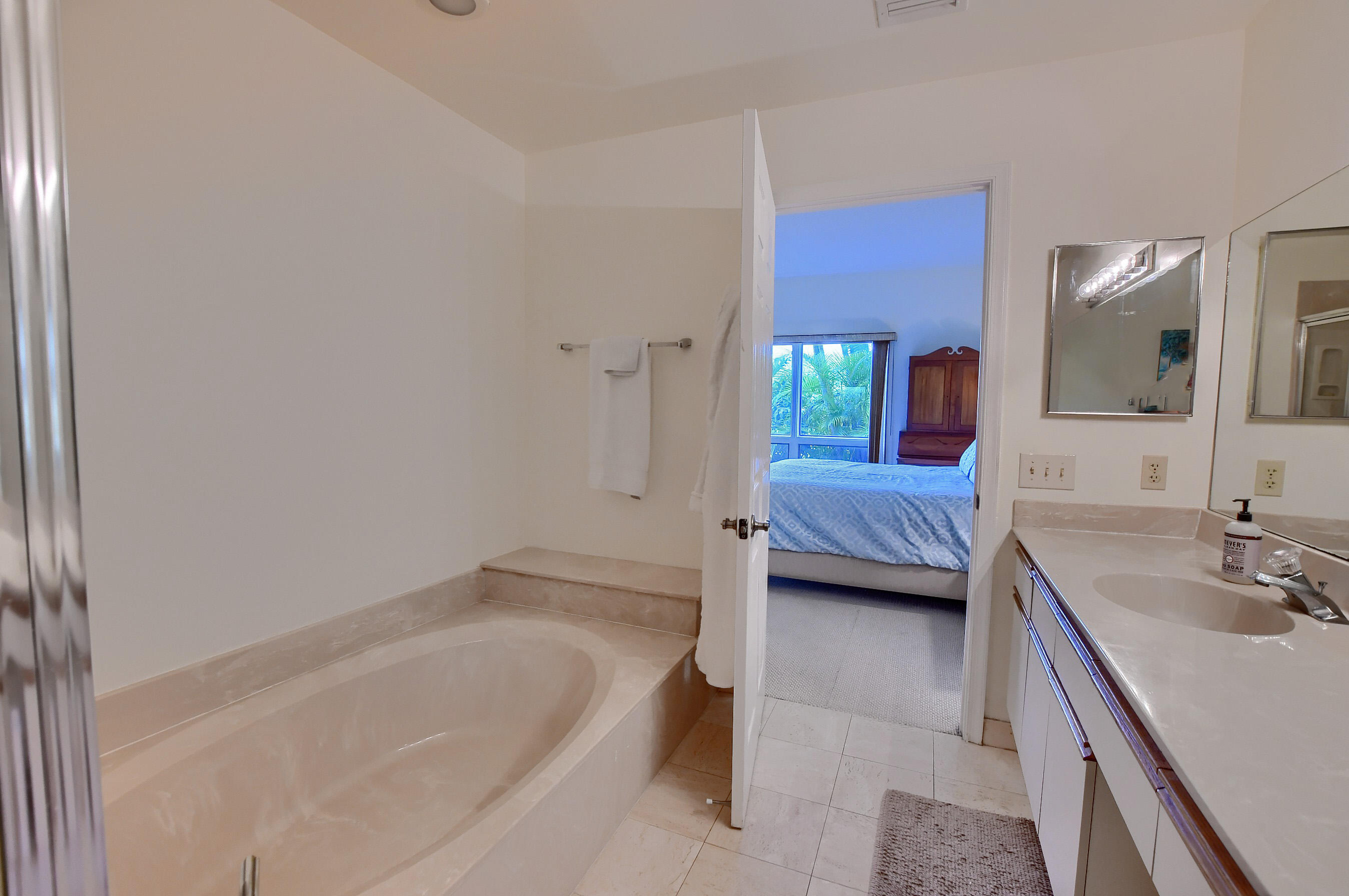7896 Seville Place, Unit 1501 Boca Raton, FL 33433 - Photo 20 of 32 a en suite bathroom with a tub sink and mirror