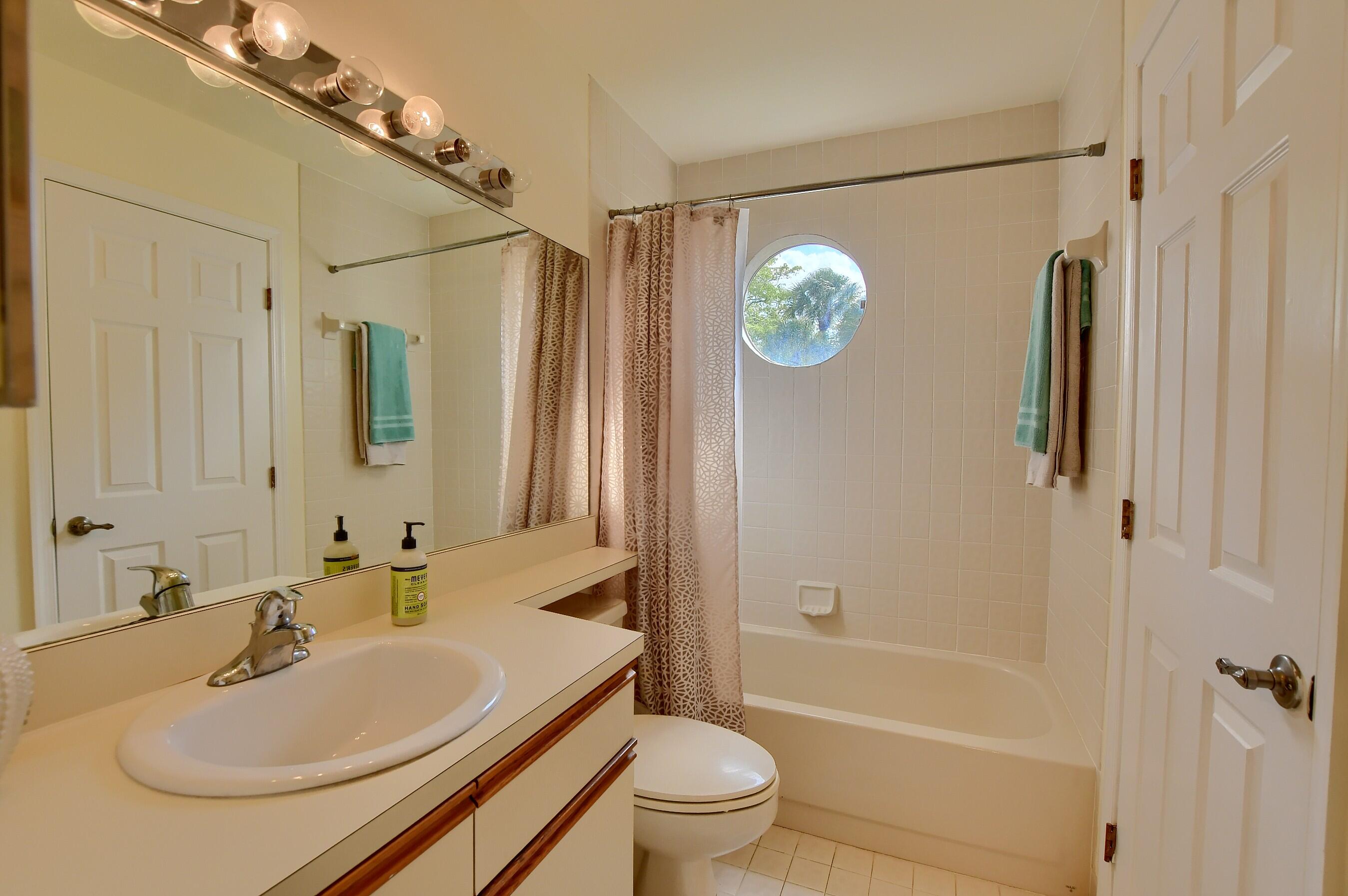 7896 Seville Place, Unit 1501 Boca Raton, FL 33433 - Photo 25 of 32 a bathroom with a sink a toilet a mirror and shower
